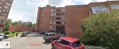 a red car parked in front of a brick building at Holiday Ap in Visaginas