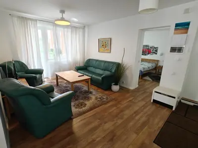 a living room with two green chairs and a table at Holiday Ap in Visaginas