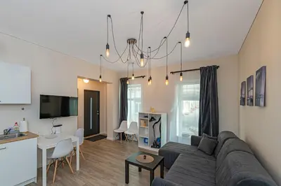 a living room with a couch and a table at Studio apartment Contrast By Polo Apartments in Kaunas