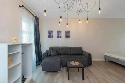 a living room with a couch and a table at Studio apartment Contrast By Polo Apartments in Kaunas