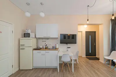a kitchen with white appliances and a table and chairs at Studio apartment Contrast By Polo Apartments in Kaunas