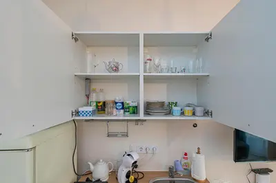 a kitchen with white shelves and a sink at Studio apartment Contrast By Polo Apartments in Kaunas