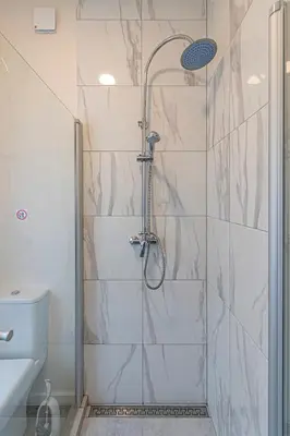 a bathroom with a shower and a toilet at Studio apartment Contrast By Polo Apartments in Kaunas
