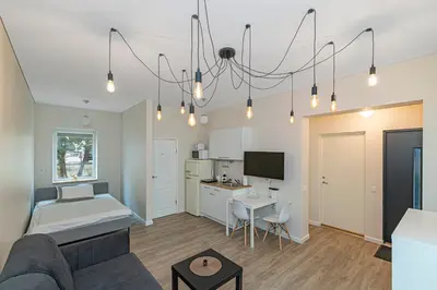 a living room with a couch and a kitchen at Studio apartment Contrast By Polo Apartments in Kaunas
