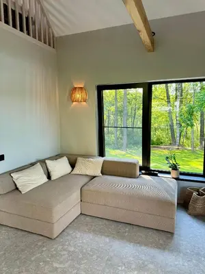 a large couch in a room with a large window at Lavender Resort in Molėtai