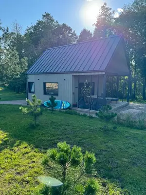 a small shed with a blue tub in a yard at Lavender Resort in Molėtai