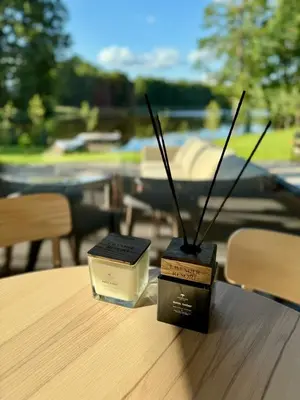 a table with two candles and a holder with sticks at Lavender Resort in Molėtai