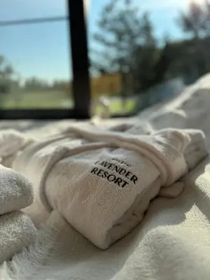 a pile of towels sitting on top of a bed at Lavender Resort in Molėtai