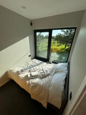 a bed in a room with a large window at Lavender Resort in Molėtai