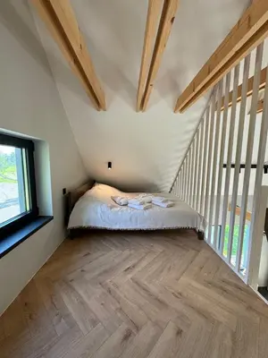 a bedroom with a bed in a room with wooden beams at Lavender Resort in Molėtai