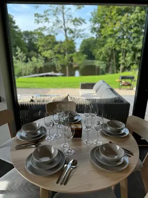 a wooden table with glasses and plates on it at Lavender Resort in Molėtai