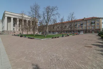 a park with benches in front of a building at G-47 Near the Parliament - Self check in in Vilnius