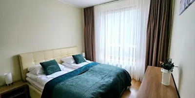a bedroom with a bed and a large window at Aquapartment Druskininkai in Druskininkai