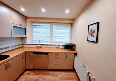 a kitchen with a counter and a sink and a window at SPACIOUS Apartment in the SUN CITY in Šiauliai