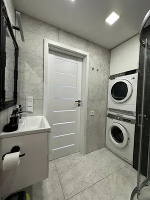 a bathroom with a washing machine and a washer at Apartments in Šiauliai city center in Šiauliai