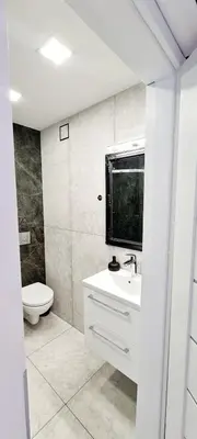 a white bathroom with a toilet and a sink at Apartments in Šiauliai city center in Šiauliai