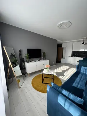 a living room with a blue couch and a tv at Apartments in Šiauliai city center in Šiauliai