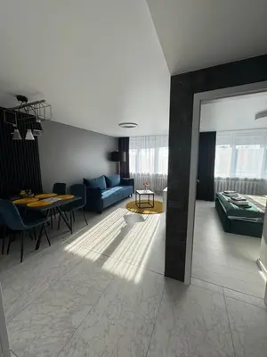 a living room with a blue couch and a table at Apartments in Šiauliai city center in Šiauliai