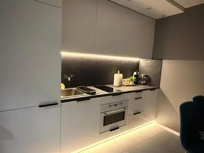 a kitchen with white cabinets and a sink at Apartments in Šiauliai city center in Šiauliai