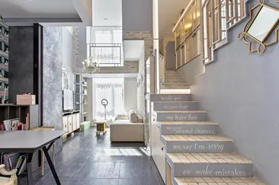 a staircase in a living room with a table at LOCUSDO Apartment no. 137 near OZAS, AKROPOLIS in Vilnius