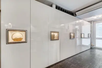 a large white wall with paintings on it at LOCUSDO Apartment no. 137 near OZAS, AKROPOLIS in Vilnius