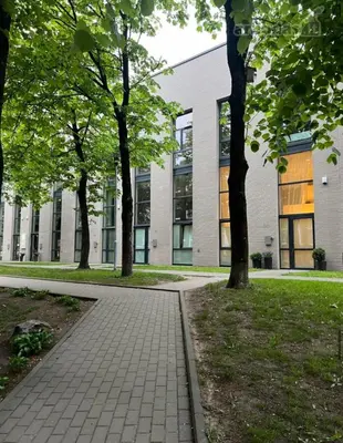 a walkway in front of a building with trees at LOCUSDO Apartment no. 137 near OZAS, AKROPOLIS in Vilnius