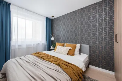 a bedroom with a large bed with blue walls at Near Gates of Dawn / Modern 1 bedroom / w/Netflix in Vilnius