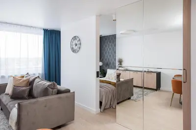 a living room with a couch and a bedroom at Near Gates of Dawn / Modern 1 bedroom / w/Netflix in Vilnius