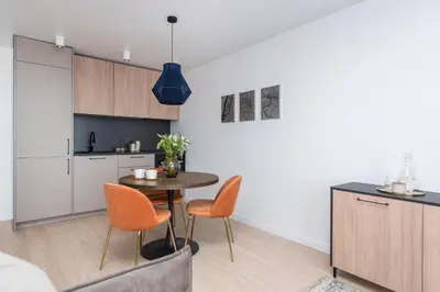 a kitchen and dining room with a table and chairs at Near Gates of Dawn / Modern 1 bedroom / w/Netflix in Vilnius