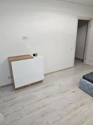 a room with a white wall and a wooden floor at Gražus ir ramus butas jonavoje in Jonava