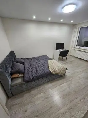 a bedroom with a bed and a desk with a computer at Gražus ir ramus butas jonavoje in Jonava