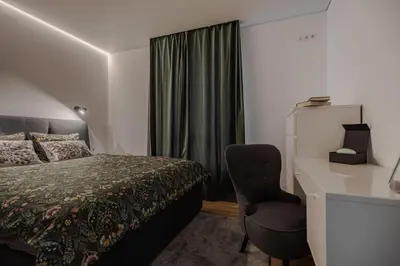 a bedroom with a bed and a desk and a chair at Fantasy House, cozzy apartmens, free parking, long stays welcome in Vilnius