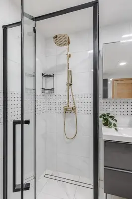 a shower with a glass door next to a sink at Fantasy House, cozzy apartmens, free parking, long stays welcome in Vilnius