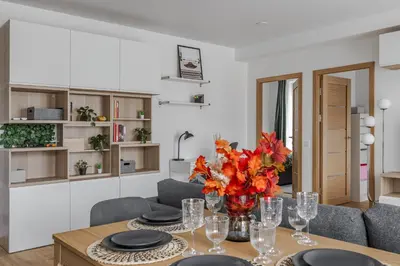 a dining room with a table with a vase of flowers at Fantasy House, cozzy apartmens, free parking, long stays welcome in Vilnius