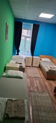 a room with four beds and a green wall at Jamaika @ Shopen in Vilnius