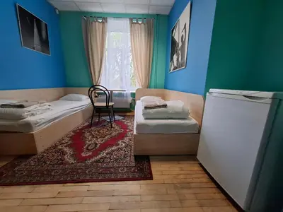 a small room with a bed and a refrigerator at Jamaika @ Shopen in Vilnius