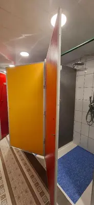 a shower stall with a yellow door in a bathroom at Jamaika @ Shopen in Vilnius
