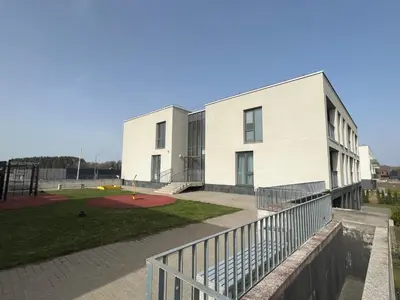 a white building with a playground in front of it at Apartment near Vilnius Outlet in Vilnius