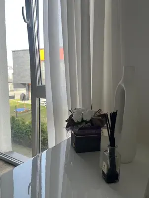 a vase with flowers on a table next to a window at Apartment near Vilnius Outlet in Vilnius