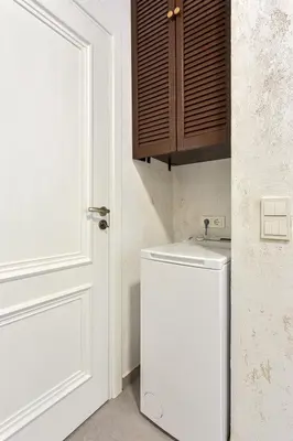 a white refrigerator in a kitchen next to a door at Apartment near Vilnius Outlet in Vilnius