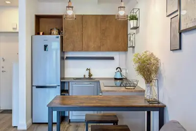 a kitchen with a table and a refrigerator at Apartment near Vilnius Outlet in Vilnius