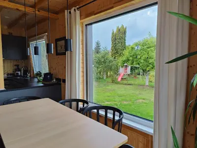 a kitchen with a table and a large window at Modern family house by the lake in Zarasai in Štadviliai
