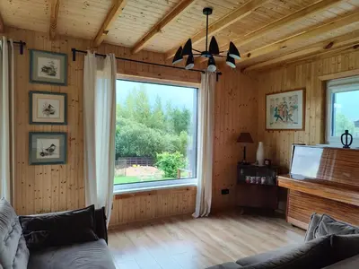 a living room with a large window and a couch at Modern family house by the lake in Zarasai in Štadviliai