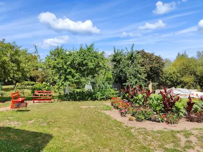 a garden with a red bench and some flowers at Modern family house by the lake in Zarasai in Štadviliai