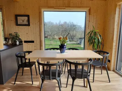 a table and chairs in a room with a window at Modern family house by the lake in Zarasai in Štadviliai