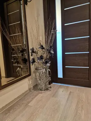 a vase with flowers in it next to a door at Butas in Kaunas