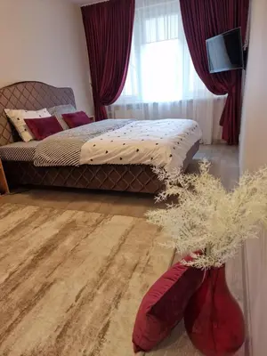 a bedroom with a bed with red curtains and red boots at Butas in Kaunas