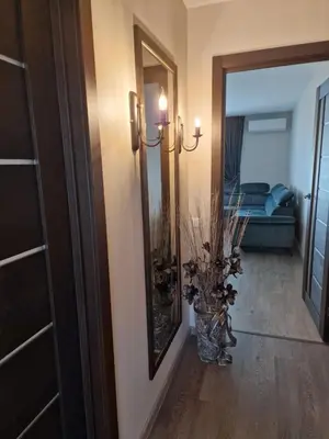 a hallway with a mirror and a vase of flowers at Butas in Kaunas