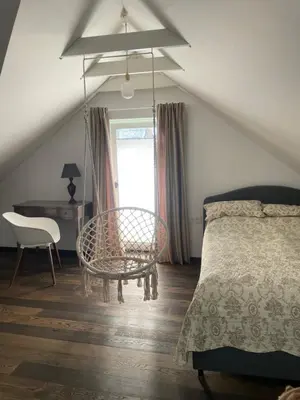 a bedroom with a bed and a table and a chair at Private Trakai Historical Centre Karaim Two Floor Apartment in Trakai
