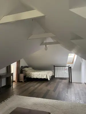 a bedroom with a bed in a attic at Private Trakai Historical Centre Karaim Two Floor Apartment in Trakai